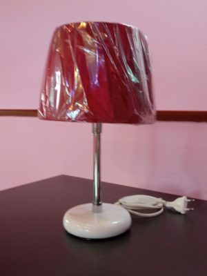 Μεταλλικό επιτραπέζιο φωτιστικό σε λευκό - ασημί χρώμα και κόκκινο καπέλο.